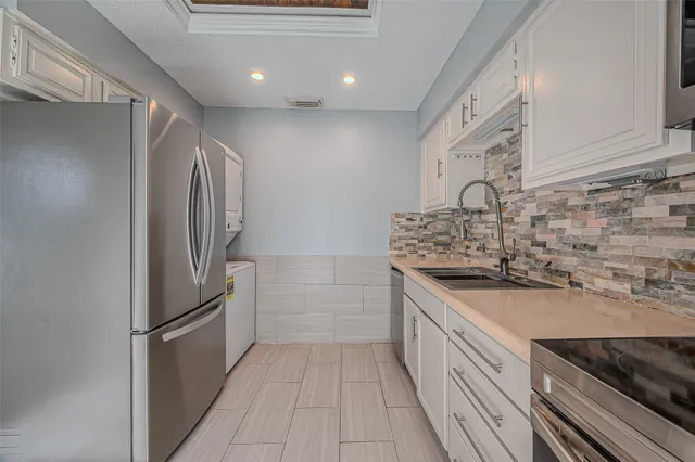 a kitchen with stainless steel appliances granite countertop a refrigerator and a sink