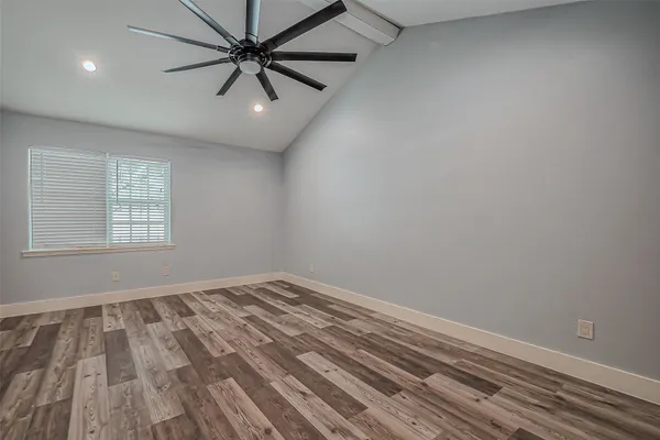 an empty room with windows and fan