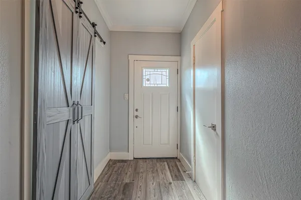 a view of a hallway with wooden floor and entryway