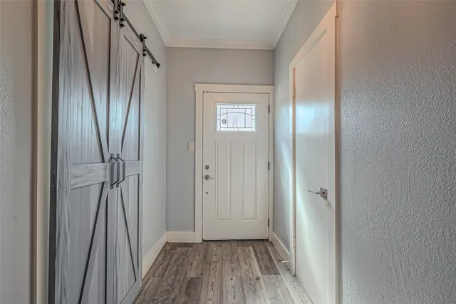 a view of a hallway with wooden floor and entryway