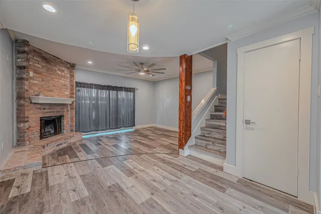 a view of a livingroom with wooden floor and a fireplace