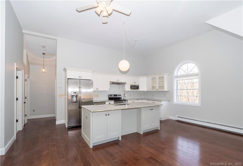 107 Black Rock Turnpike, Unit C Redding, CT 06896 - Photo 5 of 15 a kitchen with stainless steel appliances kitchen island a sink cabinets and wooden floor