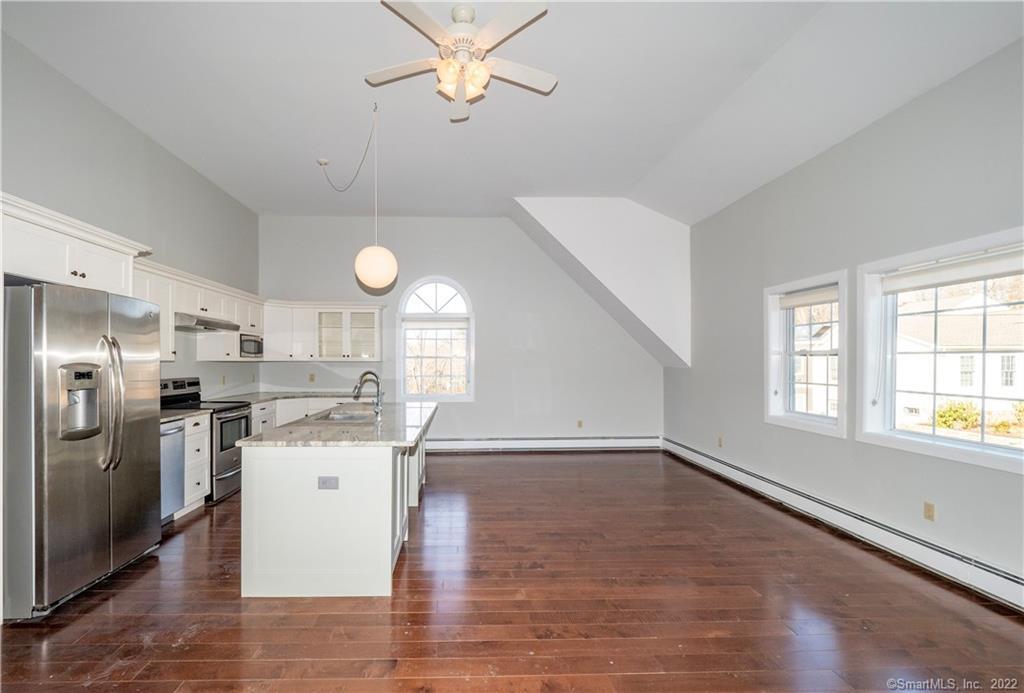 107 Black Rock Turnpike, Unit C Redding, CT 06896 - Photo 8 of 15 a kitchen with stainless steel appliances granite countertop a stove a refrigerator a sink dishwasher and white cabinets with wooden floor