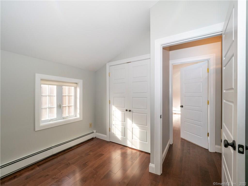 107 Black Rock Turnpike, Unit C Redding, CT 06896 - Photo 9 of 15 an empty room with wooden floor and windows