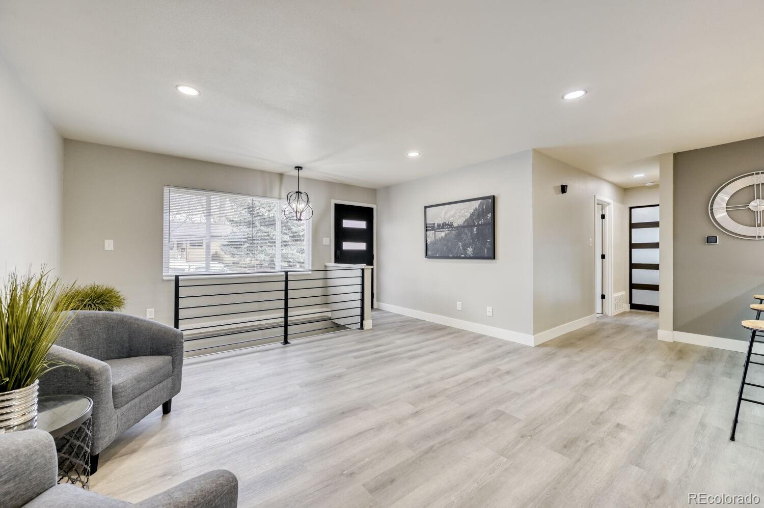 6623 Kipling Street Arvada, CO 80004 - Photo 13 of 39 a view of an empty room with a window and wooden floor