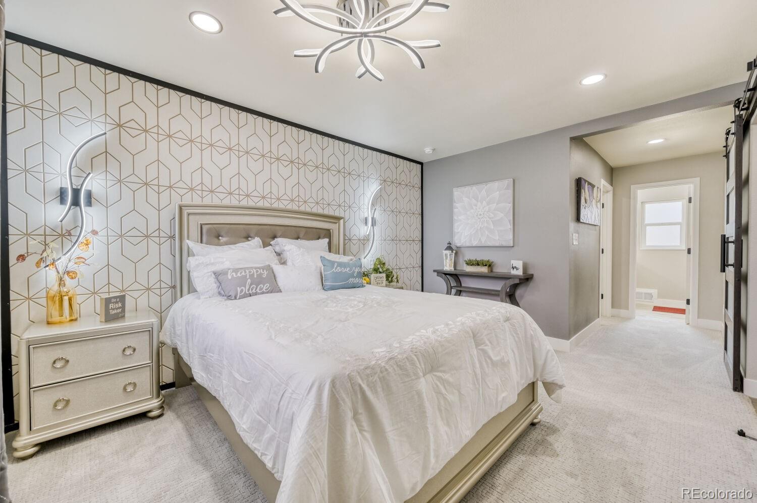 6623 Kipling Street Arvada, CO 80004 - Photo 15 of 39 a spacious bedroom with a bed and a chandelier