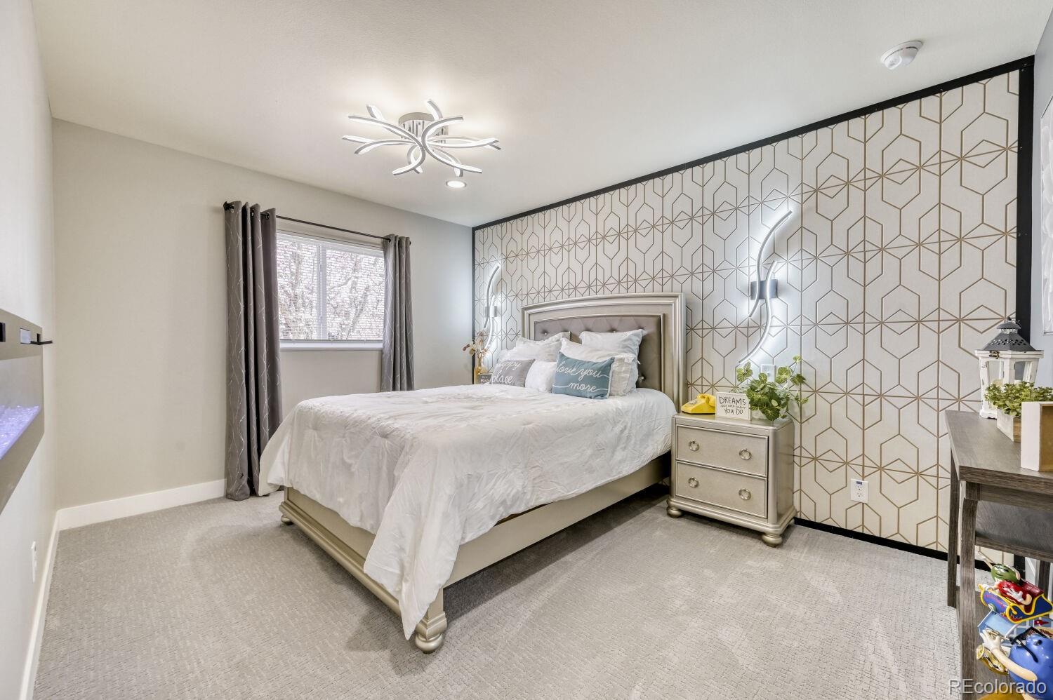 6623 Kipling Street Arvada, CO 80004 - Photo 16 of 39 a spacious bedroom with a bed and a chandelier
