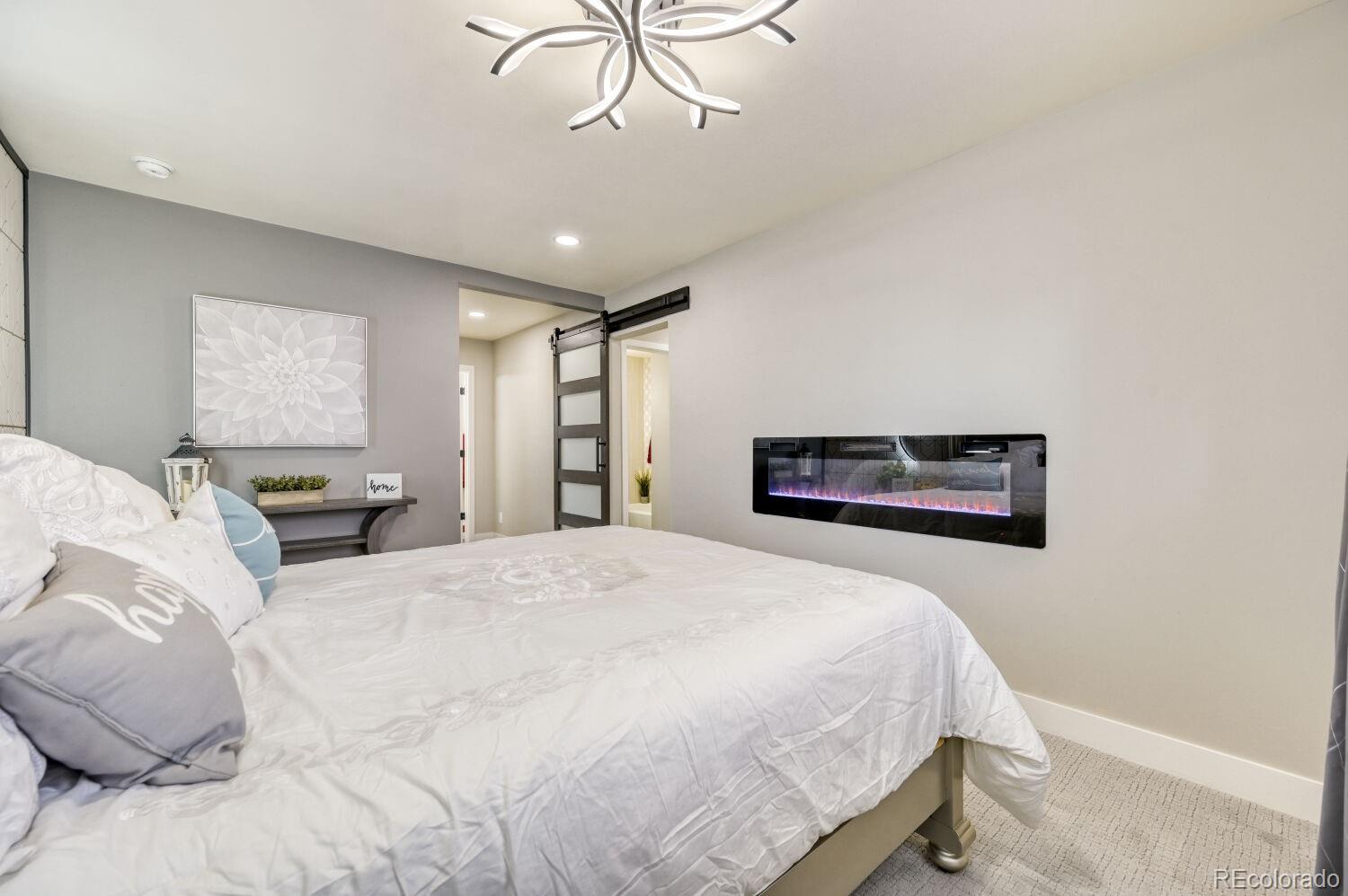 6623 Kipling Street Arvada, CO 80004 - Photo 17 of 39 a bedroom with a large bed and a chandelier