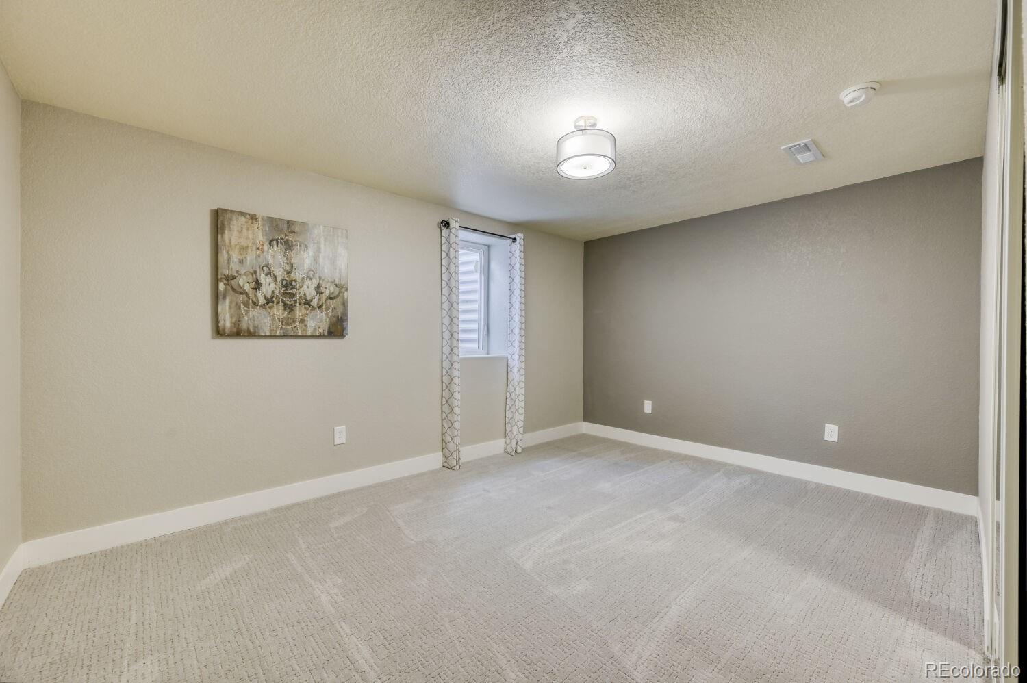 6623 Kipling Street Arvada, CO 80004 - Photo 30 of 39 an empty room with windows and closet