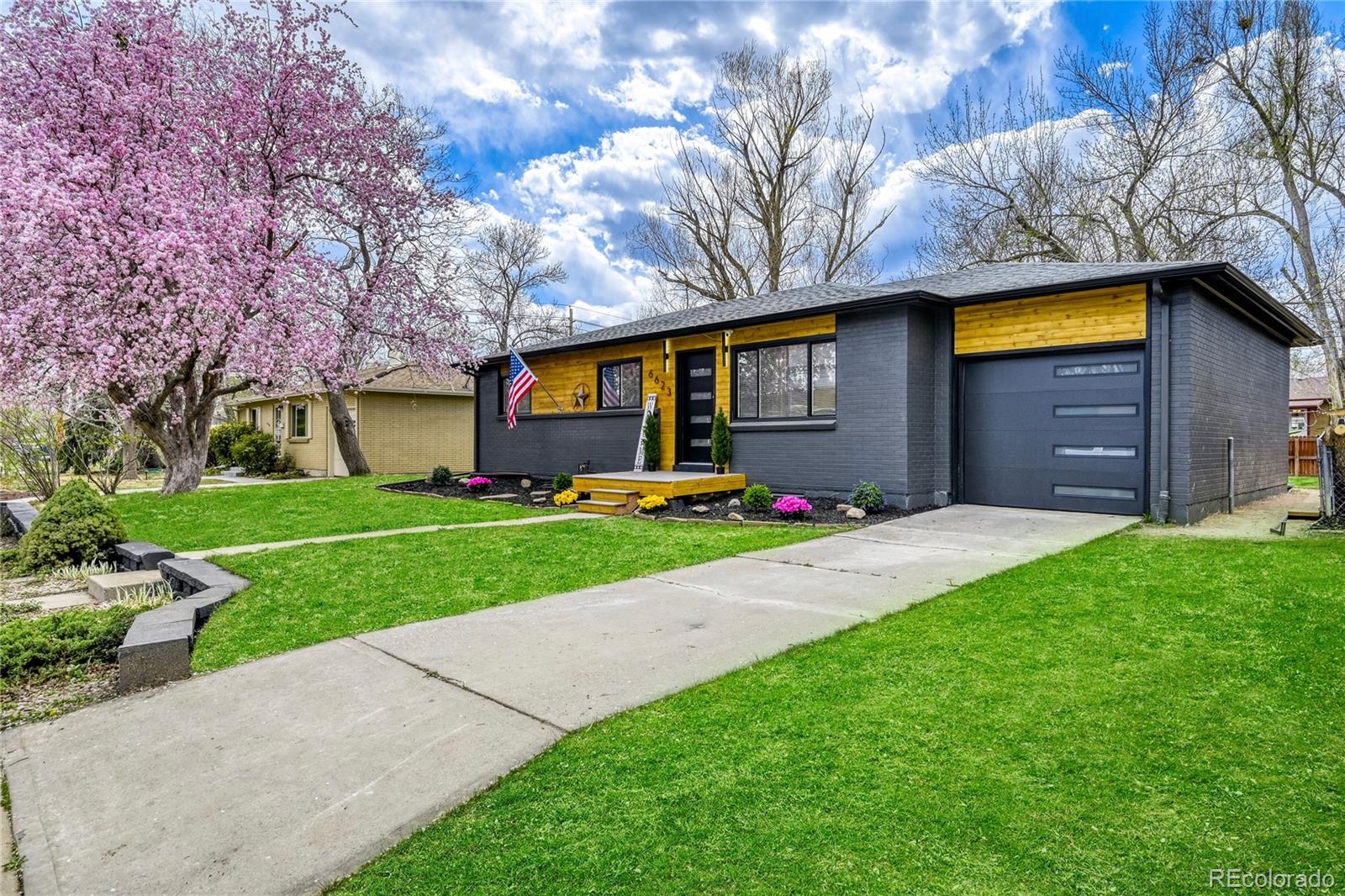 6623 Kipling Street Arvada, CO 80004 - Photo 34 of 39 a front view of a house with a yard and garage