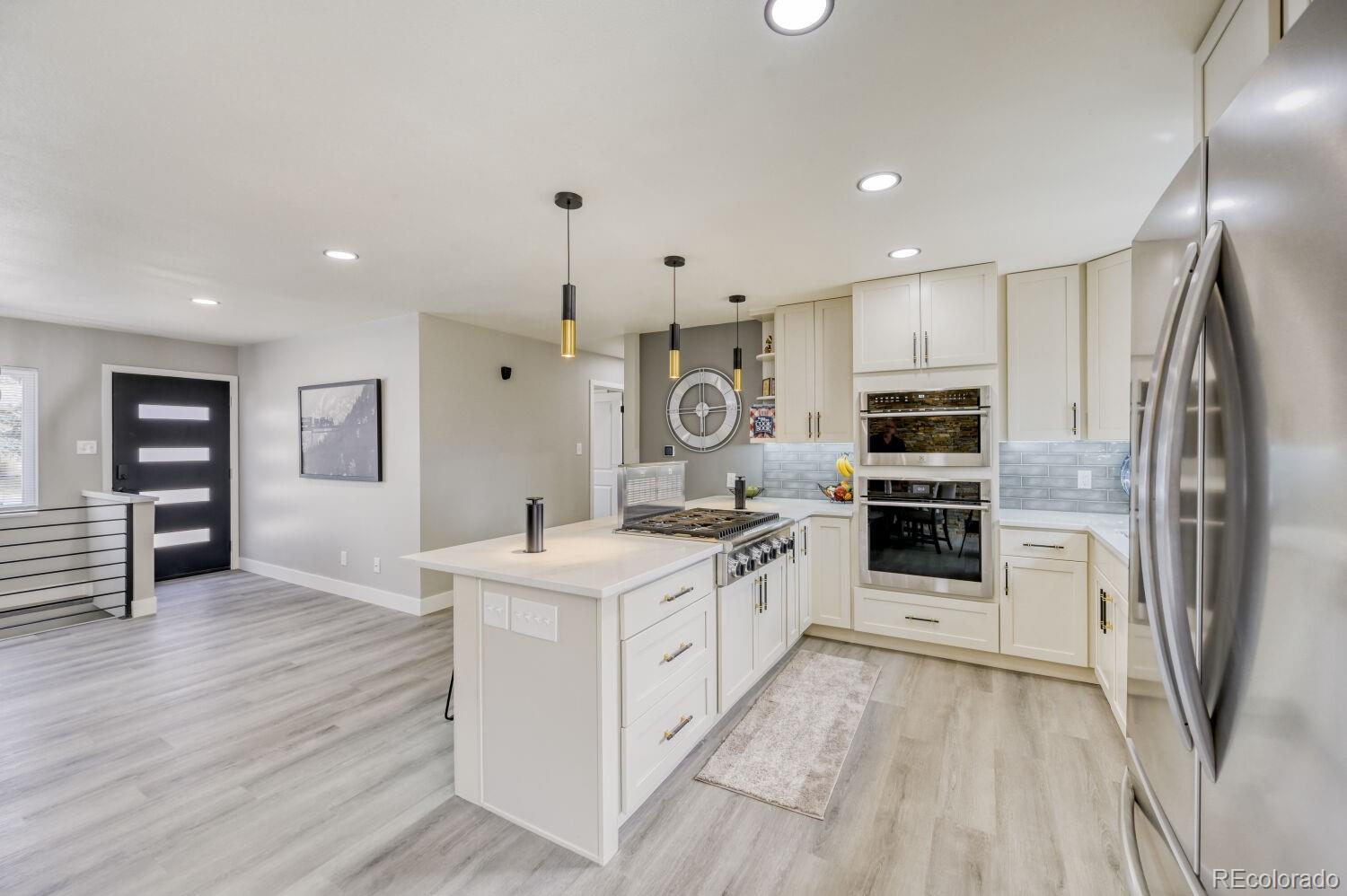 6623 Kipling Street Arvada, CO 80004 - Photo 6 of 39 a kitchen with stainless steel appliances a sink stove and refrigerator