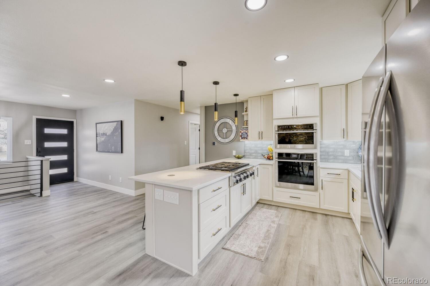 6623 Kipling Street Arvada, CO 80004 - Photo 7 of 39 a kitchen with stainless steel appliances granite countertop a refrigerator a stove and a sink