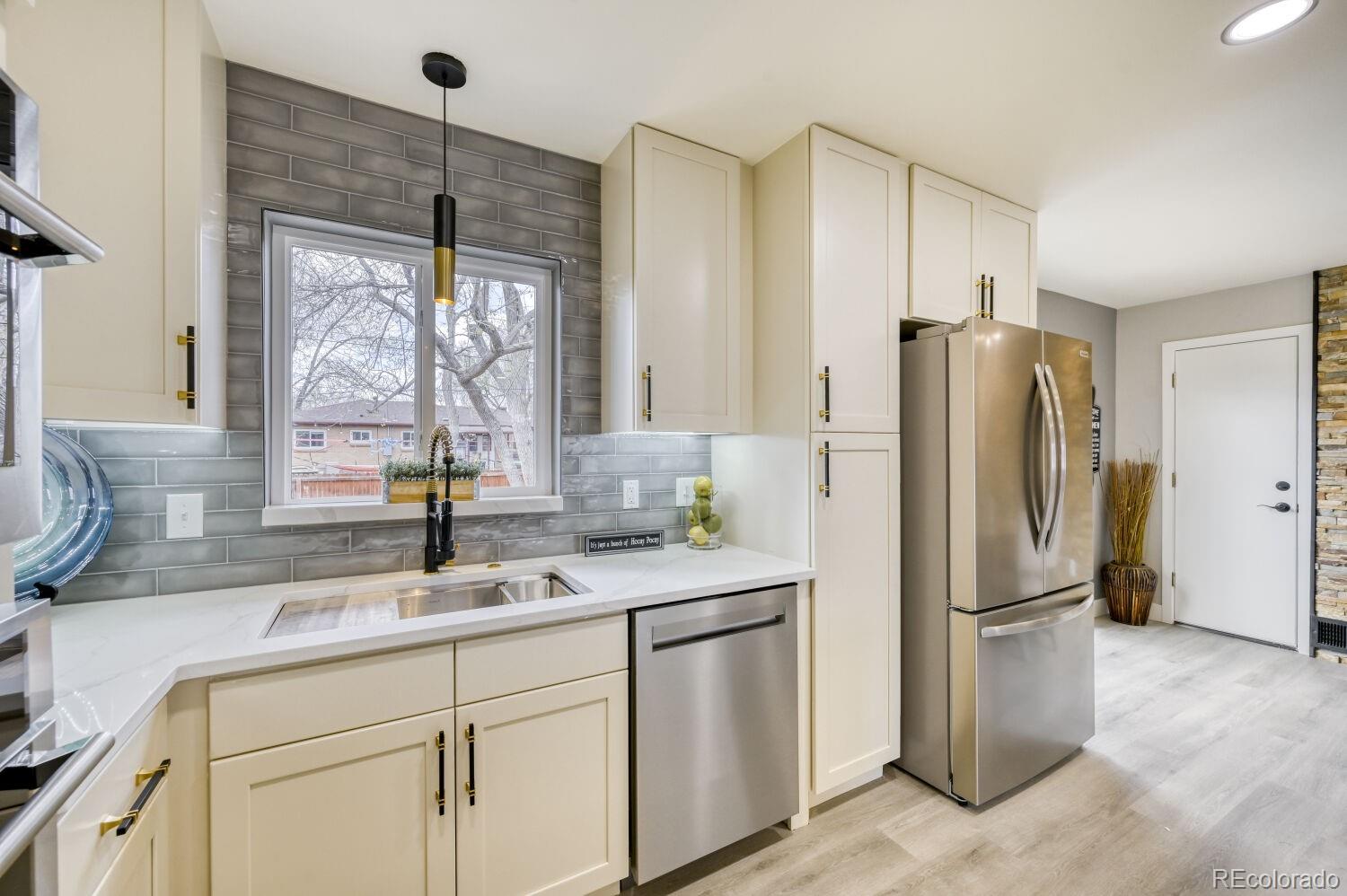 6623 Kipling Street Arvada, CO 80004 - Photo 8 of 39 a kitchen with a refrigerator a sink and cabinets