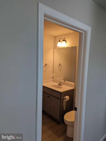 a bathroom with a granite countertop toilet a sink and a mirror