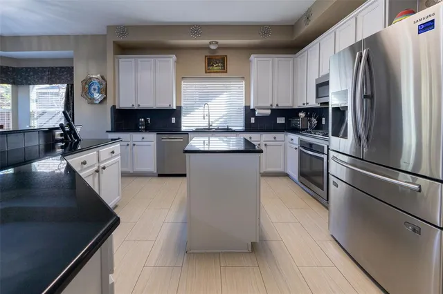 a kitchen with a refrigerator sink and cabinets