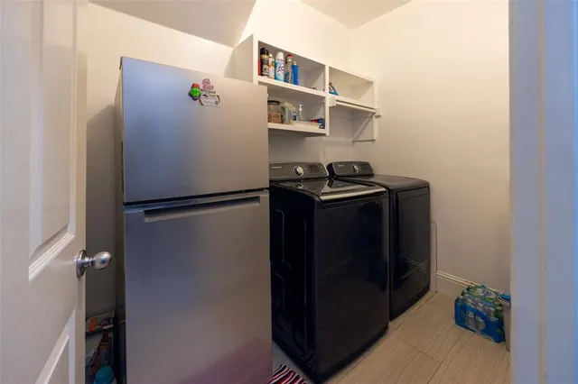 a walk in closet with wooden floor