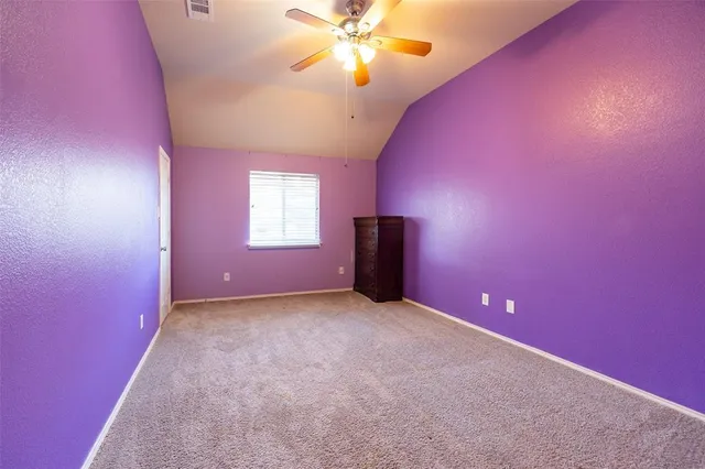 en empty room with windows and ceiling fan