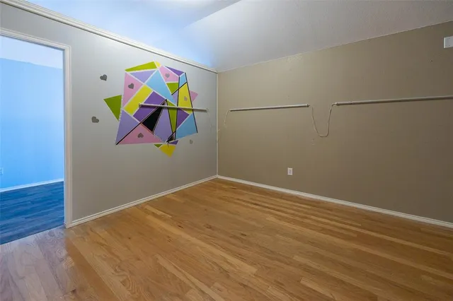 a room with wooden floor and wall paintings