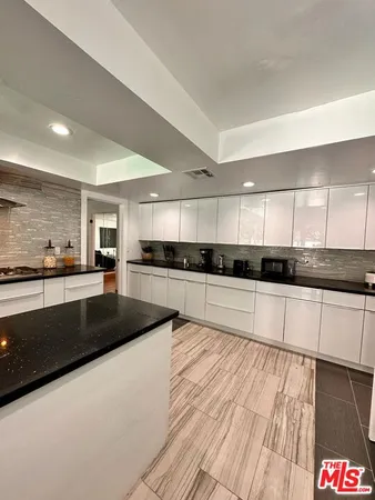 a large kitchen with stainless steel appliances granite countertop a large counter top and a stove top oven