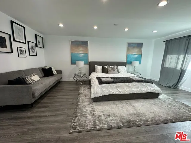 a bedroom with a large bed couch and a window