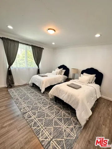 a bedroom with two beds and a large window