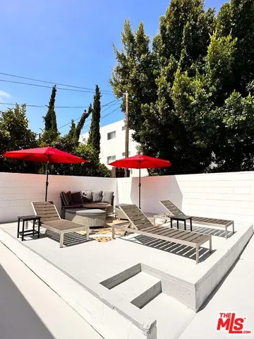 a view of a patio with table and chairs under an umbrella