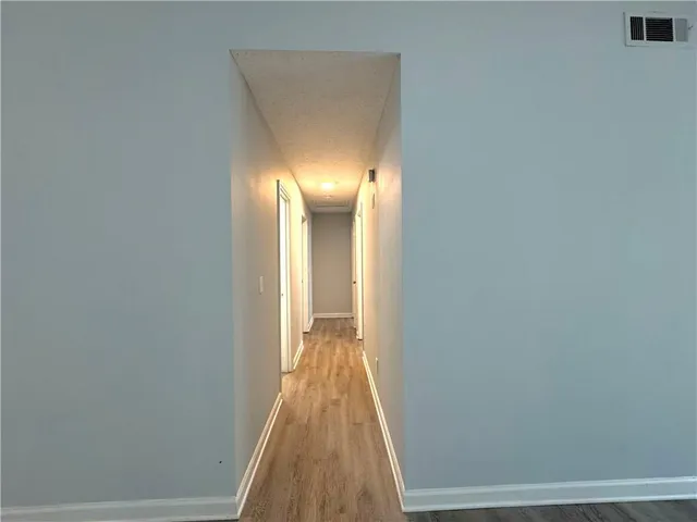a view of a hallway with wooden floor