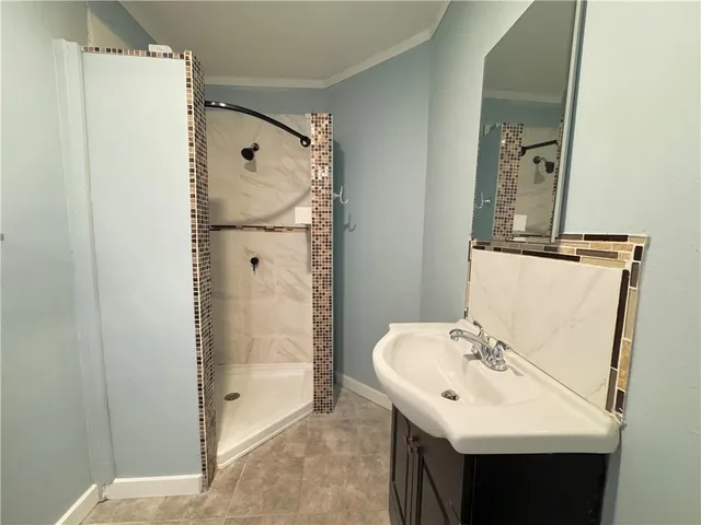 a bathroom with a shower sink and mirror