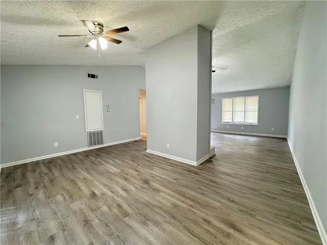 an empty room with wooden floor and window