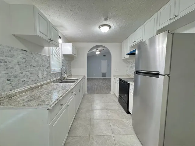 a large kitchen with a refrigerator and a sink