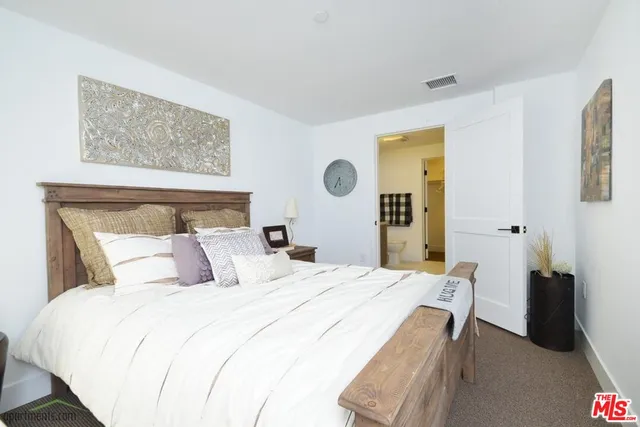 a bedroom with a bed and a painting on the wall