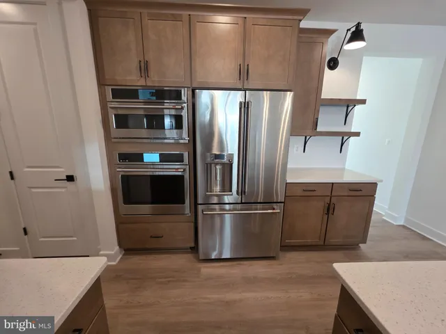a kitchen with stainless steel appliances granite countertop a refrigerator and a stove top oven