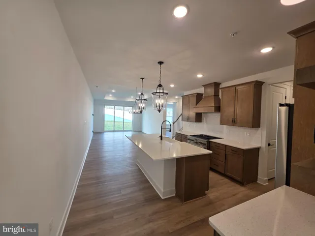 a large white kitchen with a sink and refrigerator