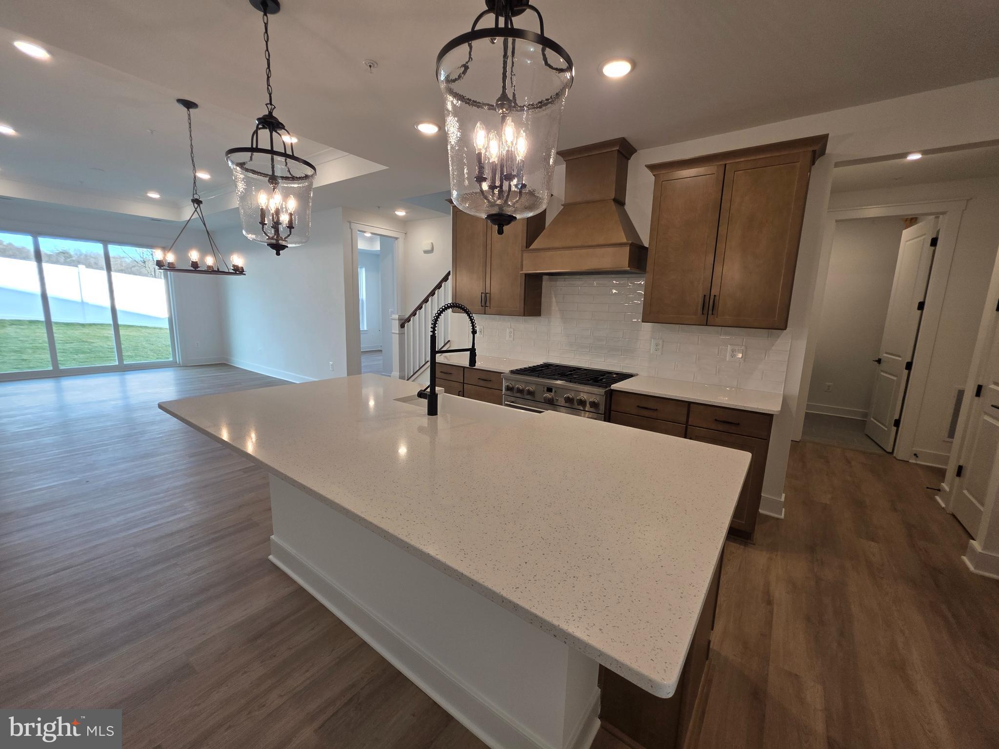 4817 Grandiflora Circle Perry Hall, MD 21128 - Photo 8 of 35 a kitchen with a sink a chandelier stainless steel appliances and wooden floor