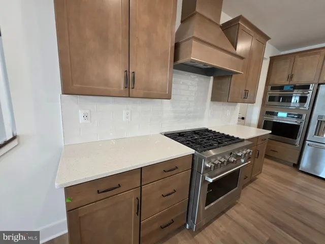 a kitchen with stainless steel appliances granite countertop a stove and a microwave with cabinets