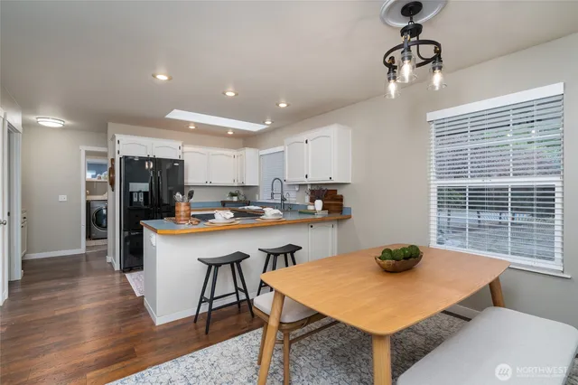 a kitchen with a table chairs and refrigerator