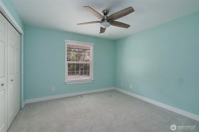 an empty room with a window and a fan