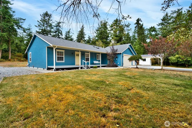 a front view of house with yard and trees around