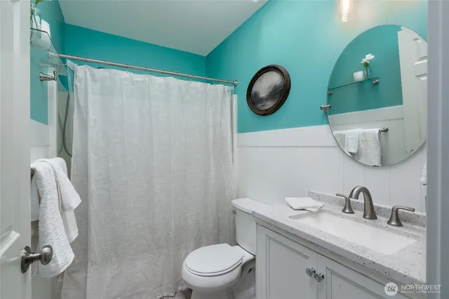 a bathroom with a toilet sink vanity and mirror