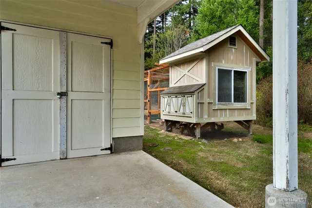 a view of backyard of house with wooden fence and large trees