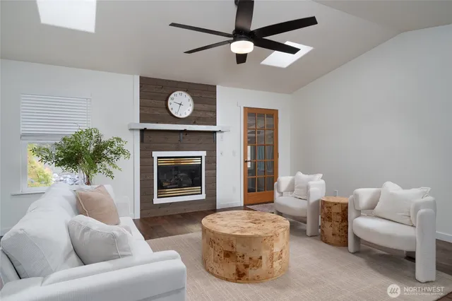 a living room with furniture a fireplace and a ceiling fan