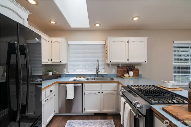 a kitchen with white cabinets and appliances