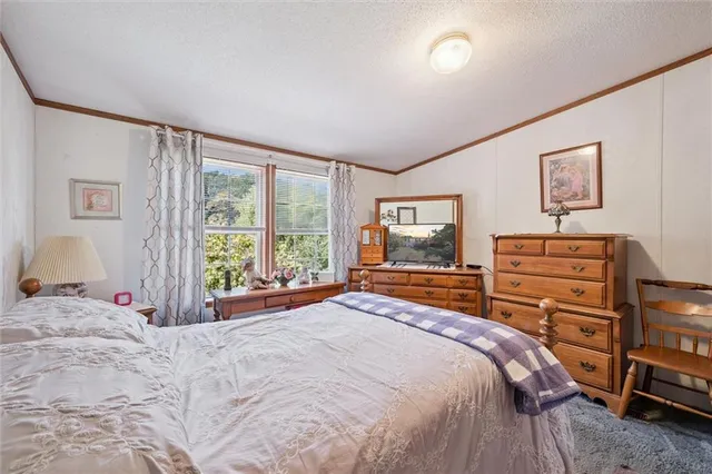 a bedroom with a bed and a large window
