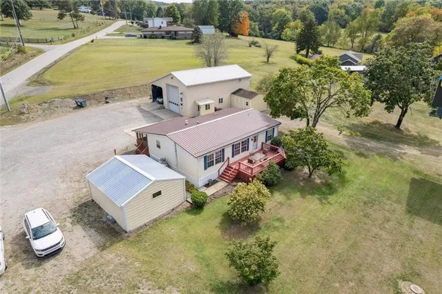 an aerial view of a house with a garden and lake view