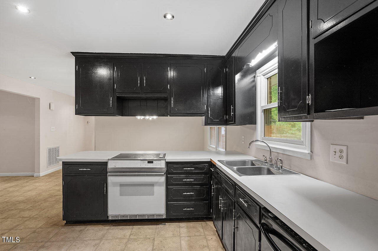 5808 Meadowbrook Road Raleigh, NC 27603 - Photo 3 of 18 a kitchen with a sink and a stove top oven with wooden floor