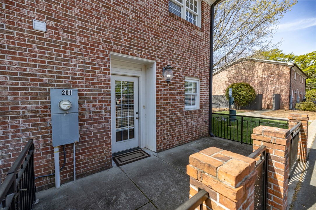 209 Calhoun Street, Unit 201 Clemson, SC 29631 - Photo 26 of 35 This inviting brick facade offers a private entrance with natural light and a fenced yard.