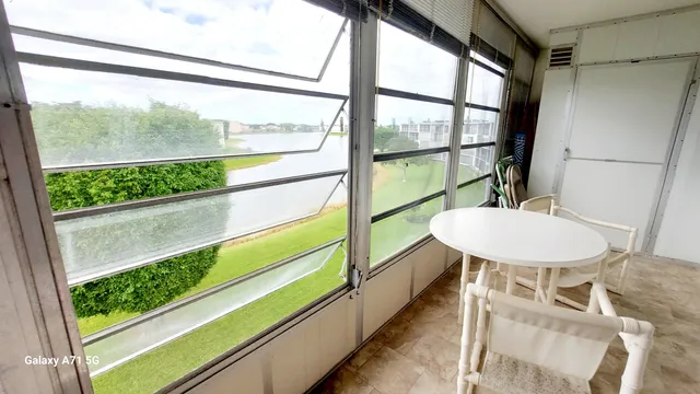 a view of a porch with furniture and a yard