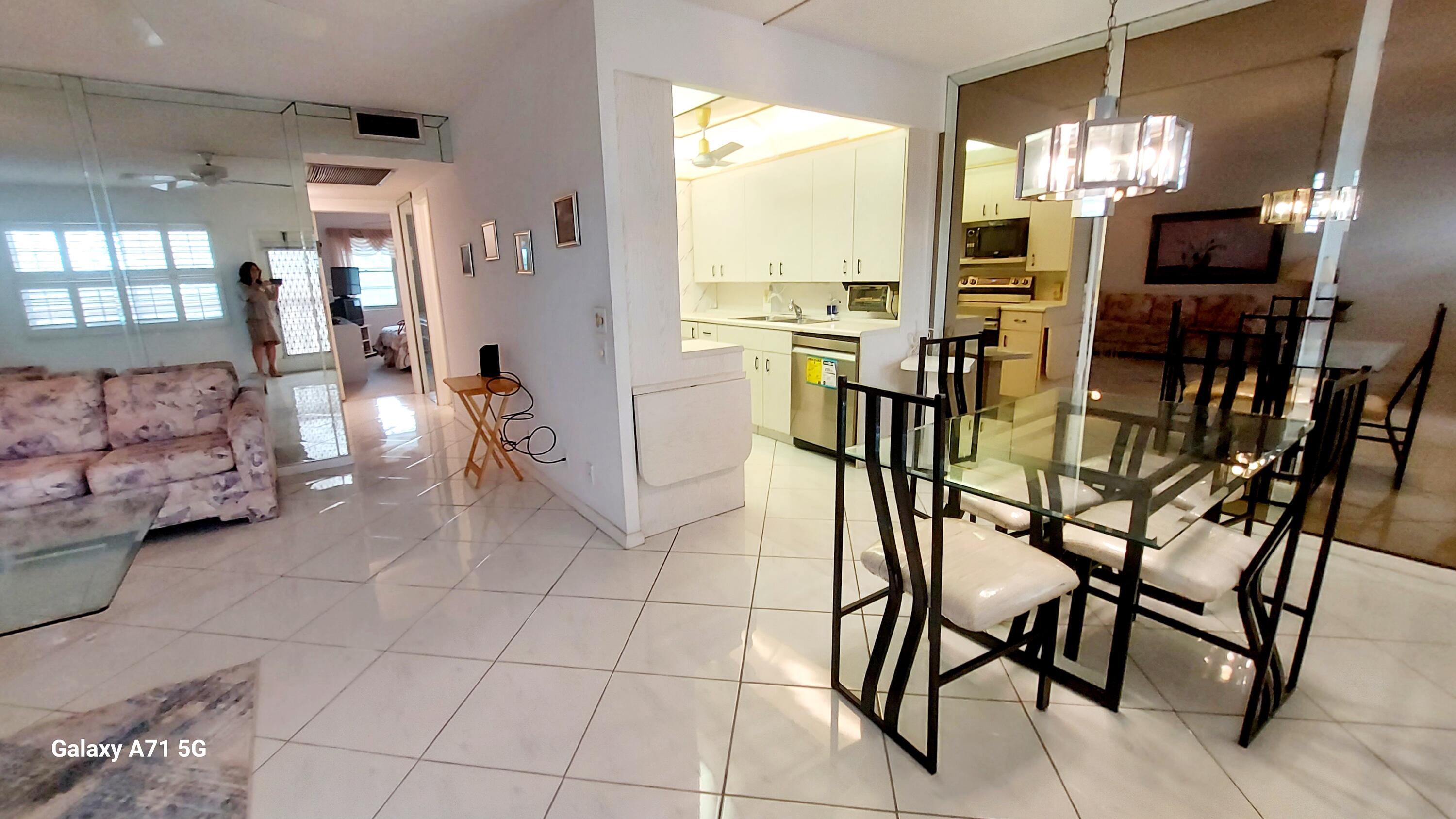 4079 Cornwall East, Unit 4079 Boca Raton, FL 33434 - Photo 7 of 41 a view of a dining room with furniture and chandelier
