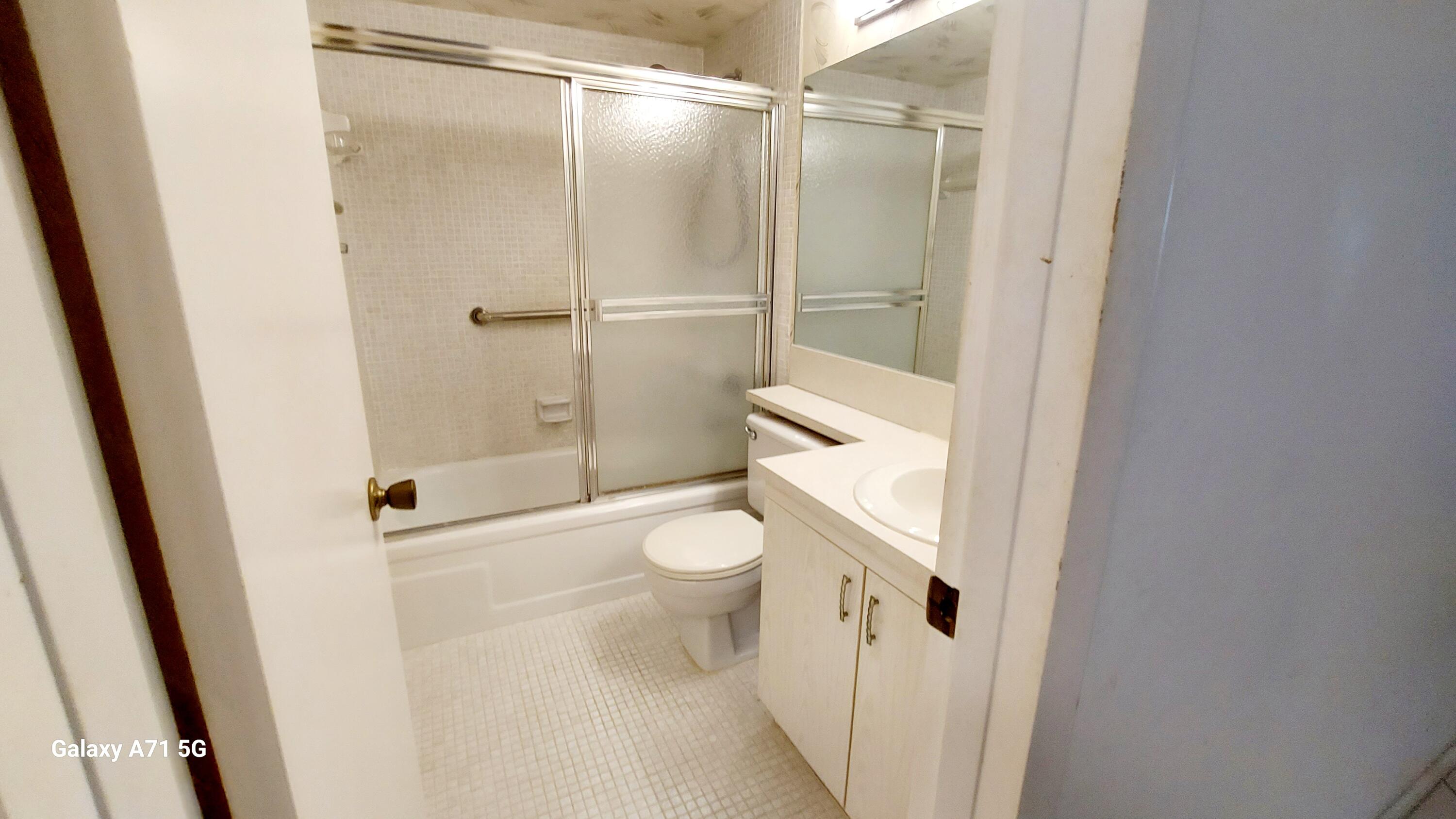 4079 Cornwall East, Unit 4079 Boca Raton, FL 33434 - Photo 8 of 41 a bathroom with a granite countertop shower and a toilet