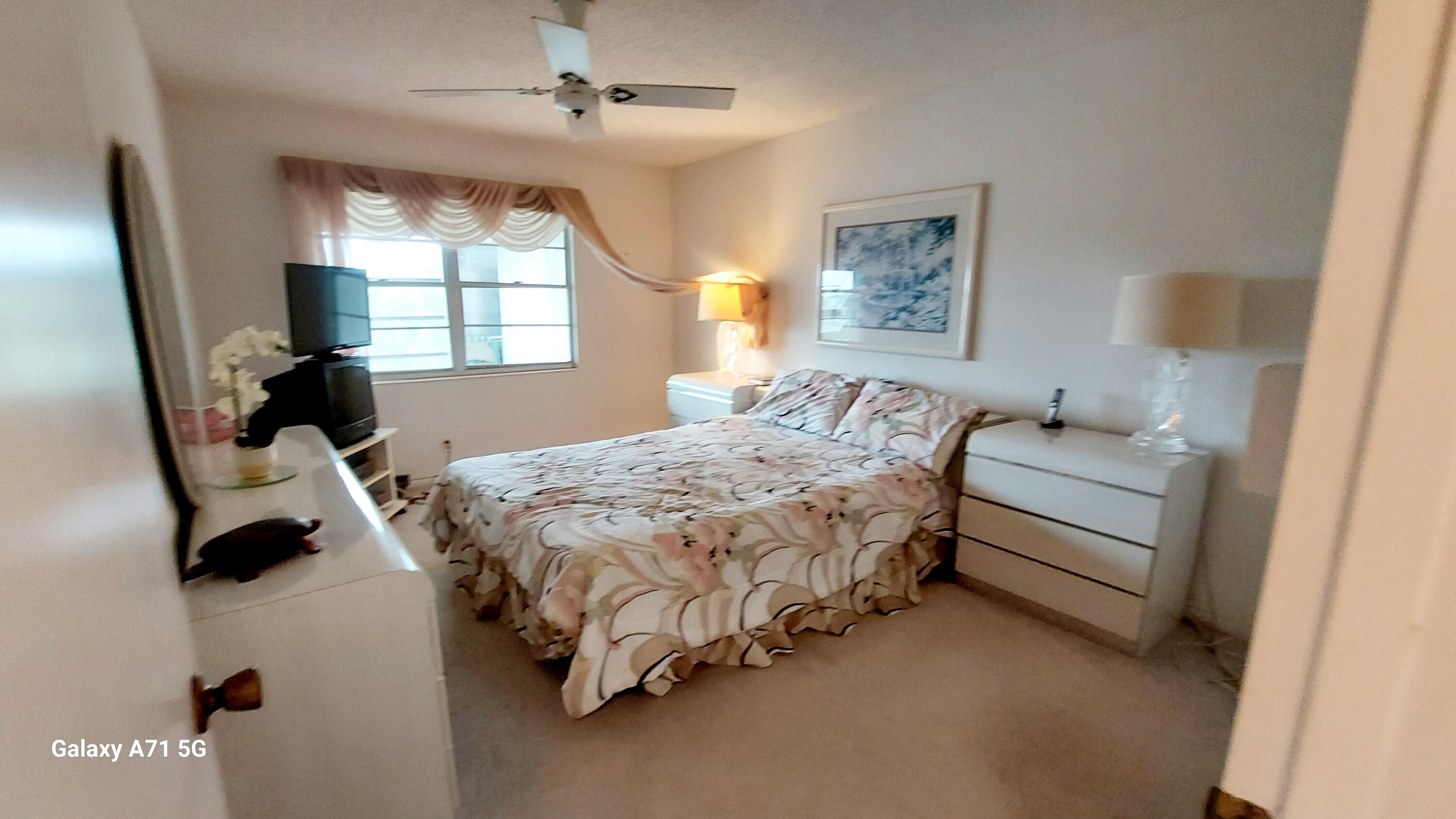 4079 Cornwall East, Unit 4079 Boca Raton, FL 33434 - Photo 9 of 41 a bedroom with a bed and a chandelier